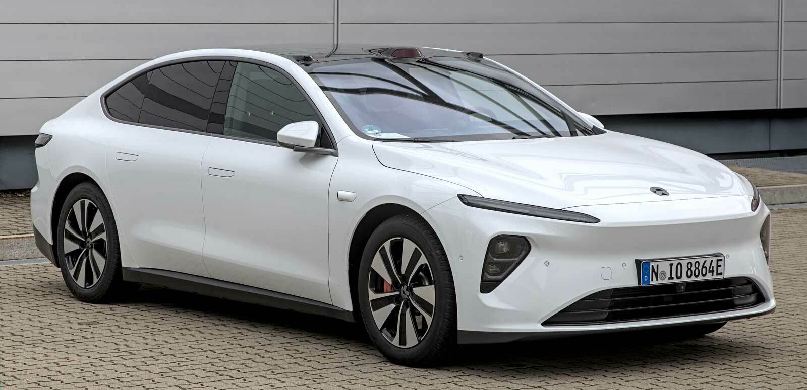 Ein weißer NIO ET7 in dynamischer Perspektive. Dieses hochmoderne Elektroauto besticht durch sein elegantes, minimalistisches Design und die charakteristische weiße Farbgebung, die für die Marke NIO steht.