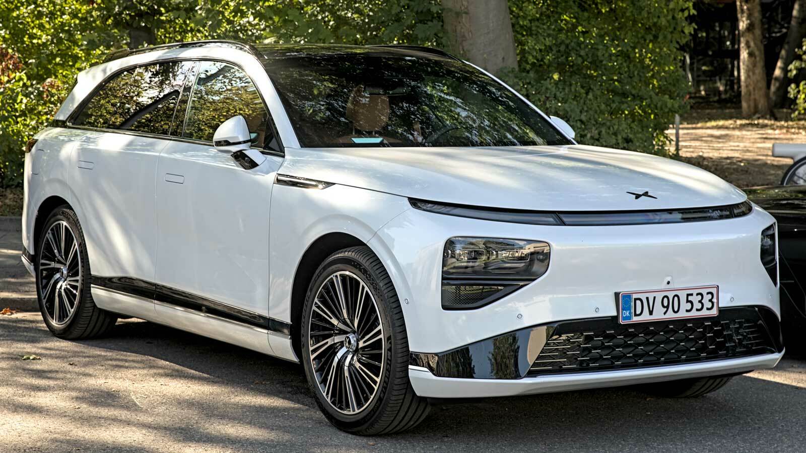 Ein weißer Xpeng G9, das neueste Modell von Xpeng Motors, abgebildet in seitlicher Ansicht. Das Fahrzeug zeichnet sich durch sein schlankes, aerodynamisches Design und eine moderne Optik aus, typisch für das Jahr 2022.
